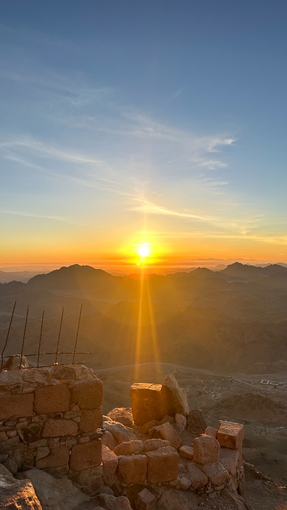 Sunrise over the Sinai mountains from a stone terrace above the desert