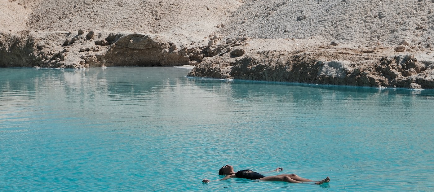 Woman floating in still turquoise water in complete rest
