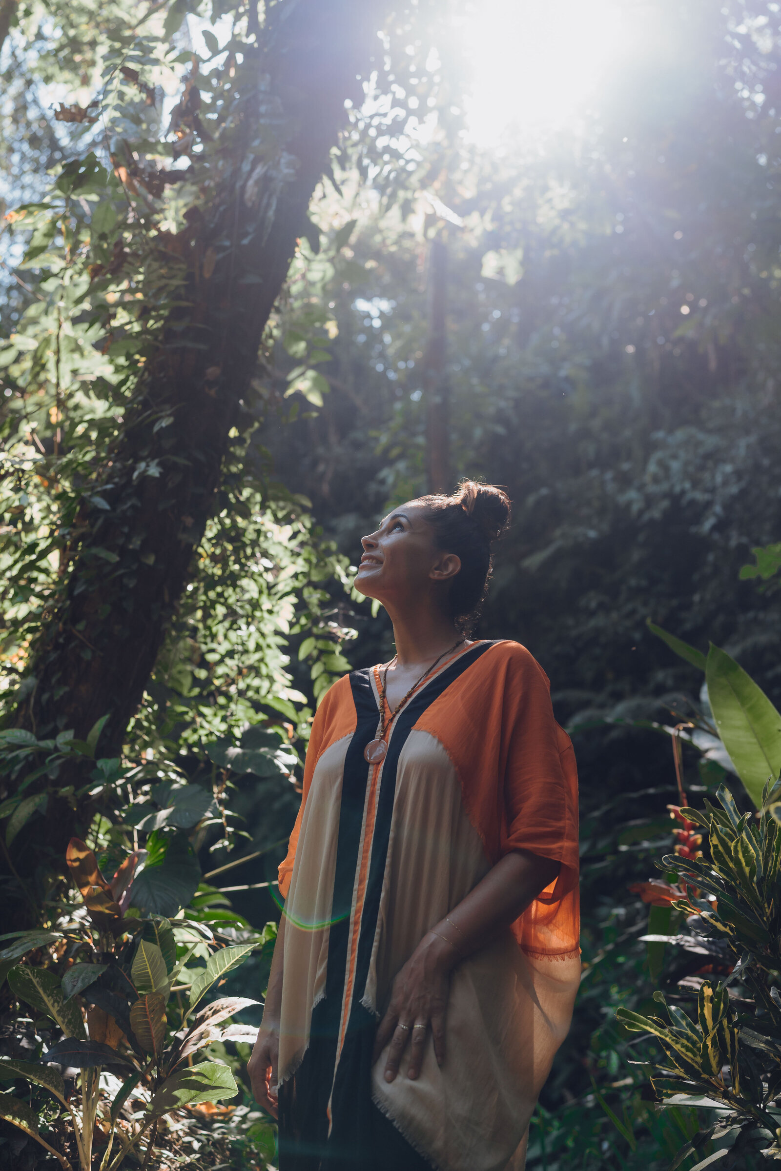 Tolo in a lush tropical landscape, face turned toward the canopy